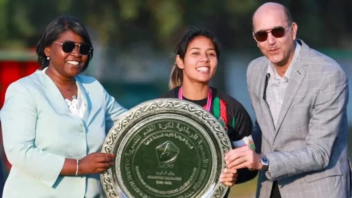 La capitaine de l'AS FAR, Ghizlane Chebbak, reçoit des mains de la présidente de la LNFF, Khadija Ila, le trophée de championne du Maroc