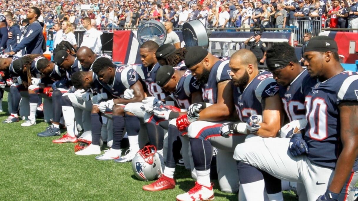 Des footballeurs américains agenouillés au moment de l'hymne national US.