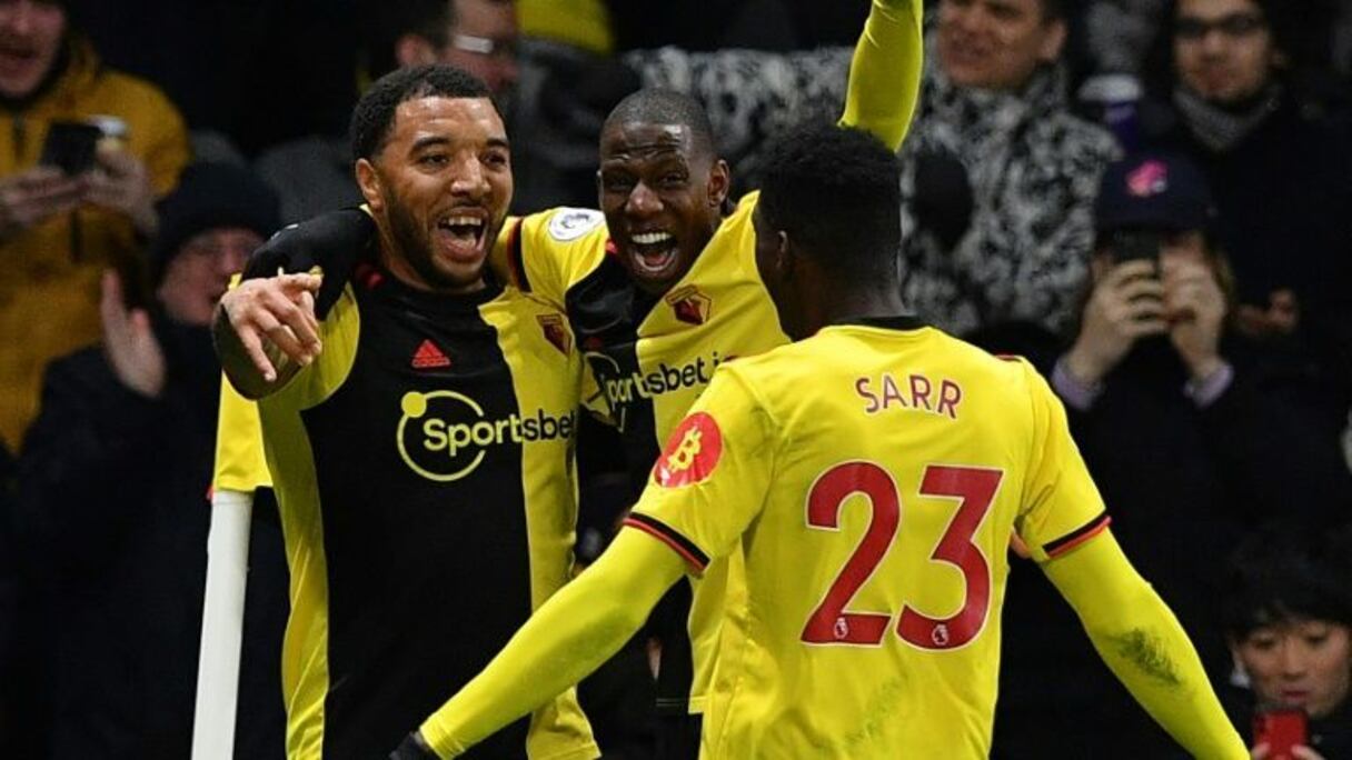 Le capitaine de Watford Troy Deeney (à gauche) aux côtés du milieu français Abdoulaye Doucouré (au centre) et du milieu sénégalais Ismaïla Sarr lors d'un match de Premier League à domicile face à Liverpool le 29 février 2020.