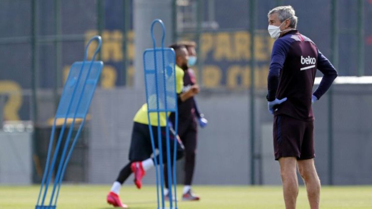Le coach du Barça Quique Setién, masque obligatoire, supervise une séance de ses joueurs à la cité sportive Joan Gamper, le 8 mai 2020.