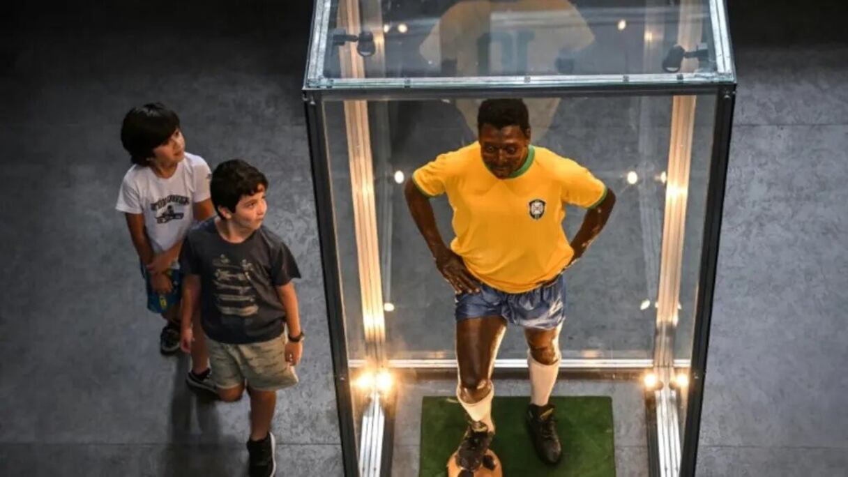 Deux enfants regardent une statut de Pelé dans le musée qui lui est consacré à Santos, le 27 décembre 2022.