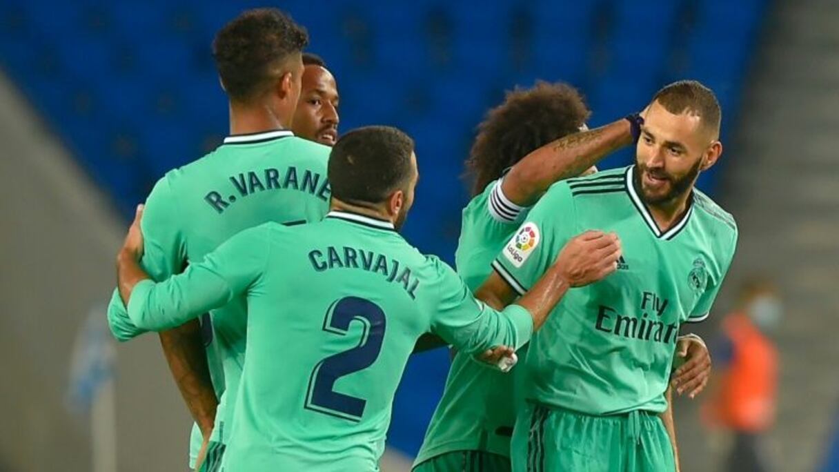 L'attaquant français du Real Madrid, Karim Benzema (d), félicité par ses coéquipiers après son but lors du match de Liga face à la Real Sociedad, à San Sebastian, le 21 juin 2020.