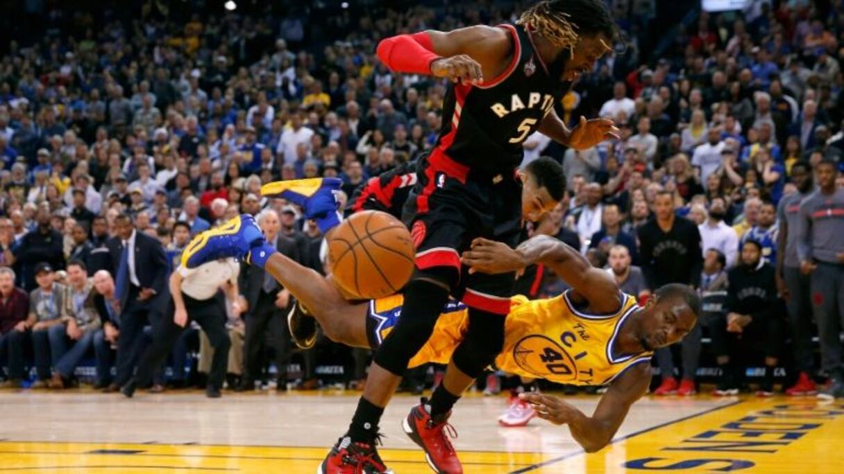Harrison Barnes, des Golden State Warriors, plonge pour sauver une balle face à DeMarre Carroll des Toronto Raptors.