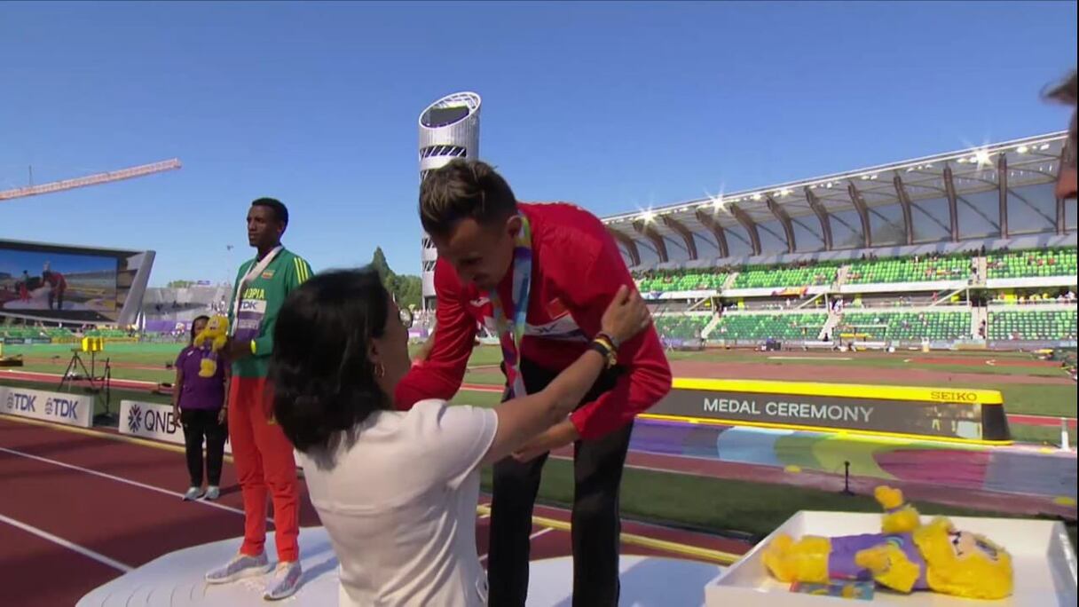 Soufiane El Bakkali recevant la médaille d'or de la main de Nawal El Moutawakkel.