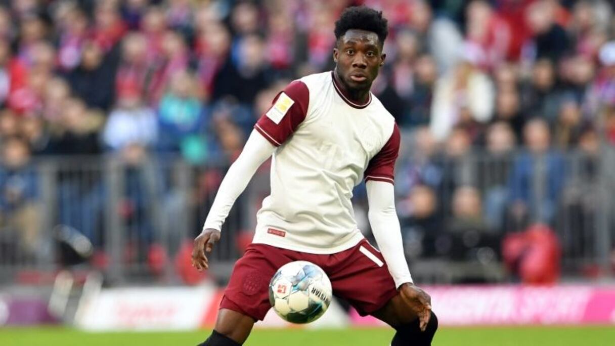 Le milieu canadien du Bayern, Alphonso Davies (c), aux prises avec le milieu autrichien de Düsseldorf, Kevin Stöger (d), lors du match de Bundesliga à Munich, le 30 mai 2020.