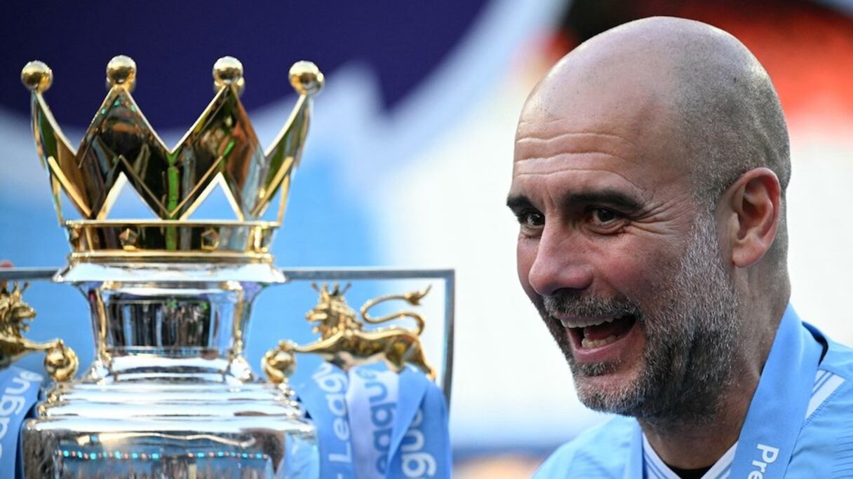 Pep Guardiola posant avec le trophée de Premier League.
