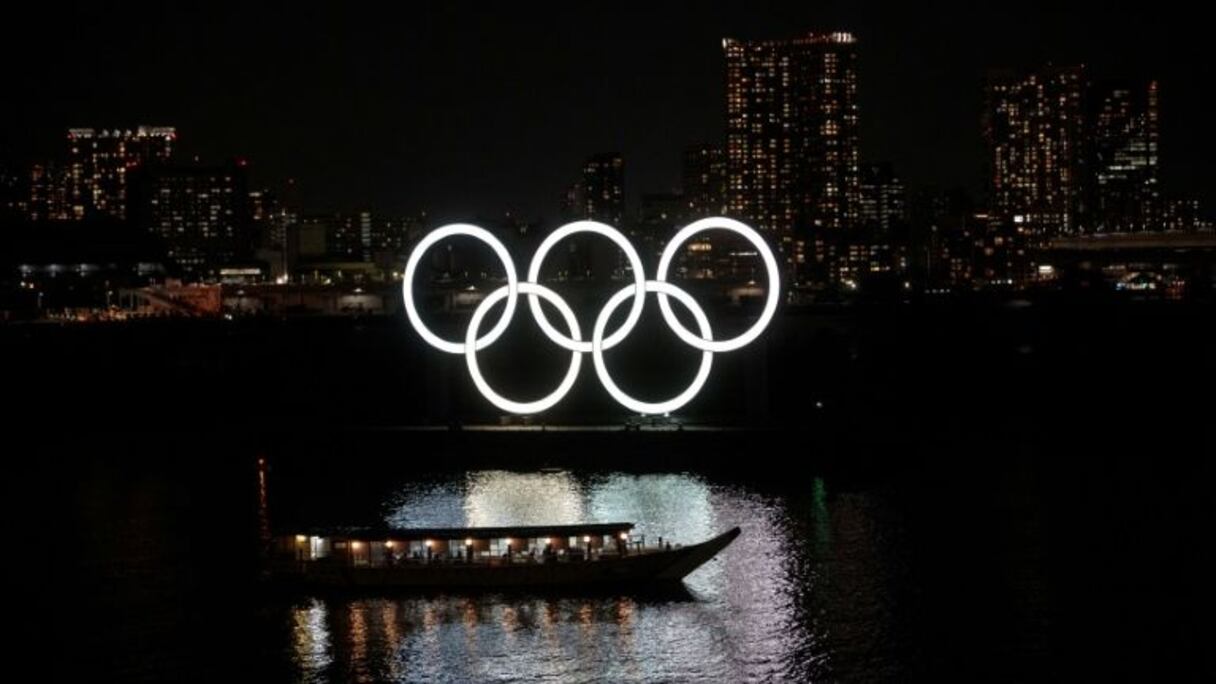 Les anneaux olympiques se reflètent dans l'eau dans le district d'Odaiba district le 23 mars 2020.