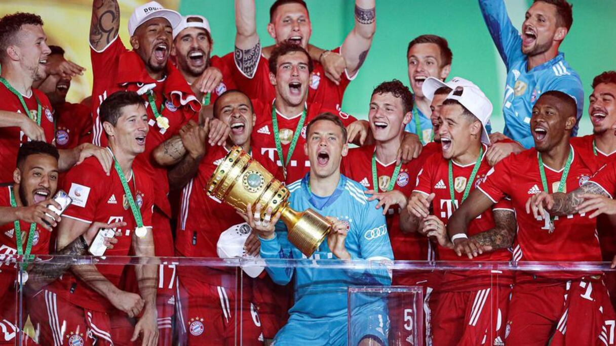 Le gardien du Bayern, Manuel Neuer (c), brandit le trophée de la Coupe d'Allemagne et célèbre avec ses coéquipiers la victoire en finale face à Leverkusen, le 4 juillet 2020.