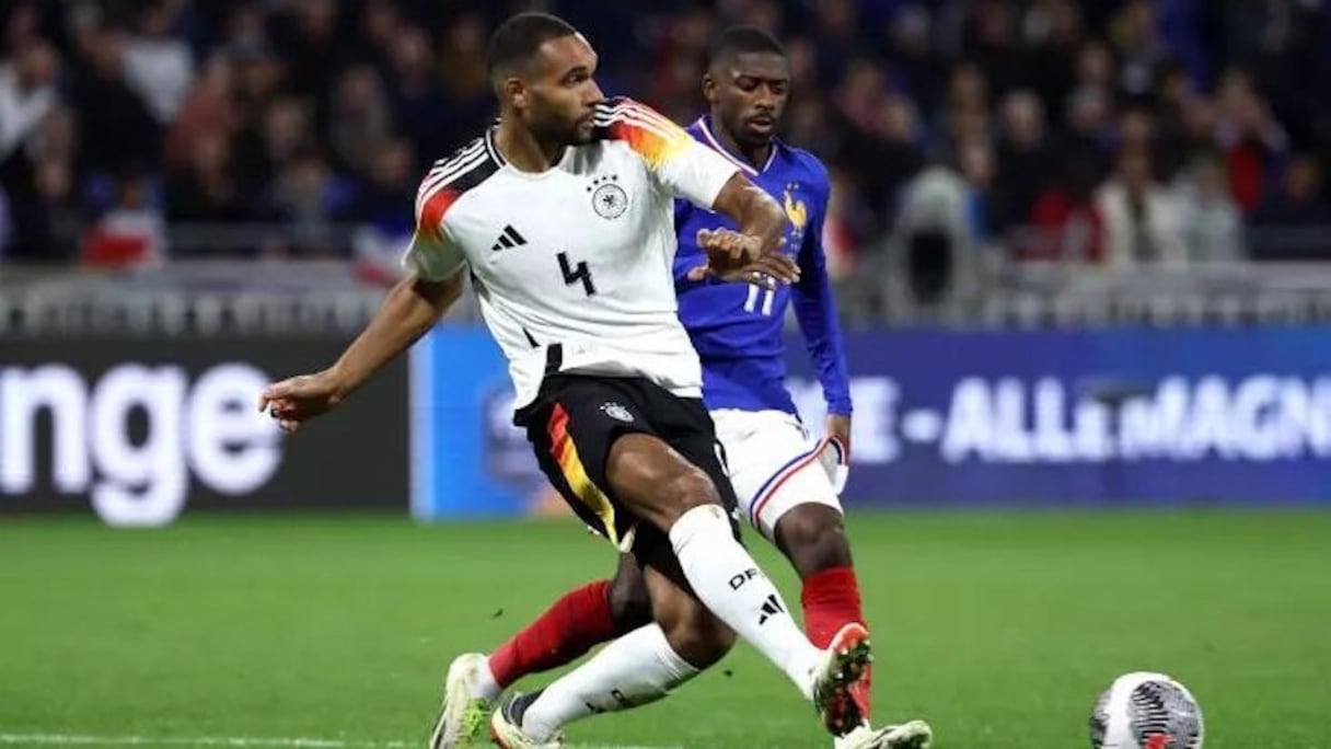 Le défenseur allemand Jonathan Tah devant l'attaquant français Ousmane Dembele, le 23 mars 2024 à Lyon. La police de caractères va être modifiée, le chiffre 4 ressemblant au S de l'insigne des SS nazis.