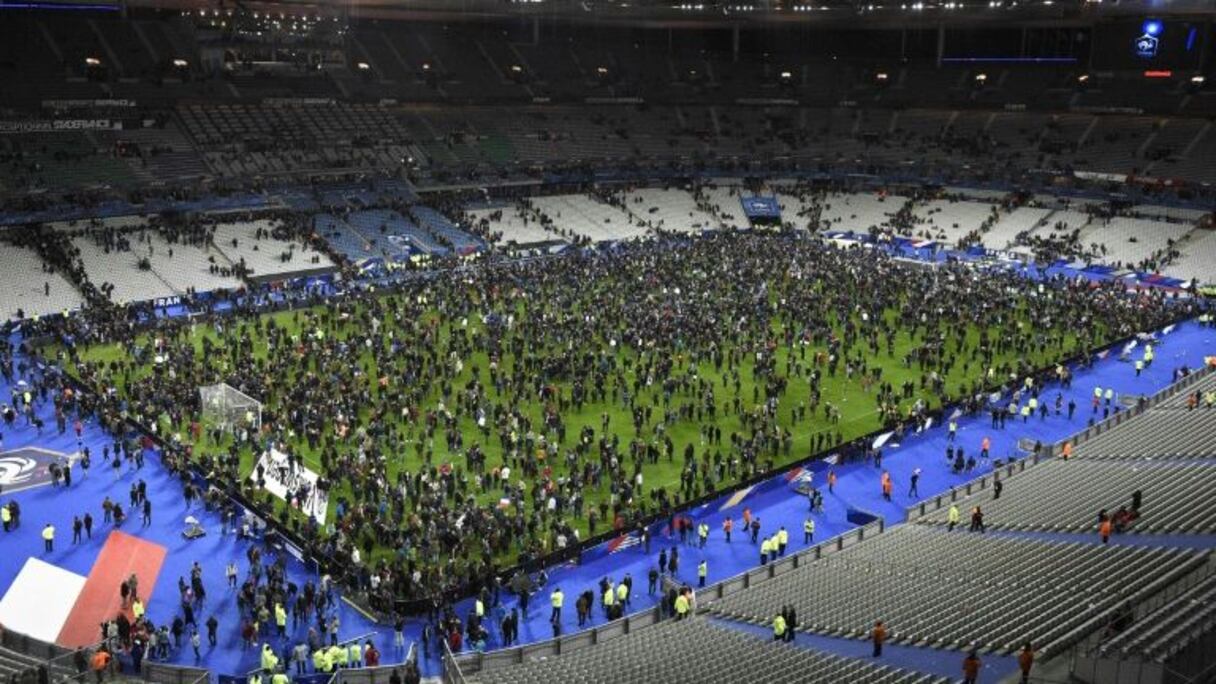 La pelouse du stade de France envahie par les spectateurs le 13 novembre 2015 à Saint-Denis après les attaques terroristes .