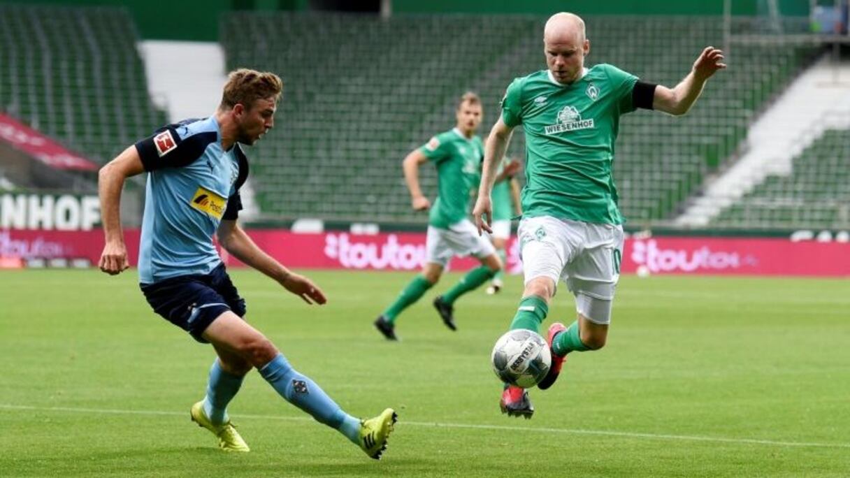 Le milieu de Mönchengladbach, Christoph Kramer (d), aux prises avec le défenseur de Brême, Davy Klaassen, lors du match de Bundesliga, à Brême, le 26 mai 2020.