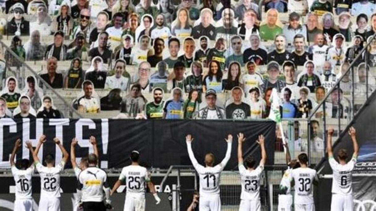 Des footballeurs allemands saluent des supporters fictifs, en temps de crise sanitaire.