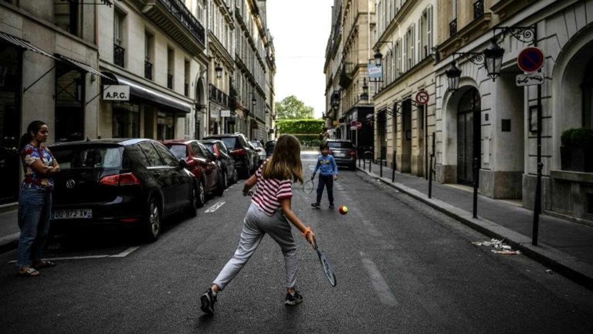 Des enfants jouant au tennis dans une rue de Paris pendant le confinement lié à la pandémie de coronavirus le 21 avril 2020.