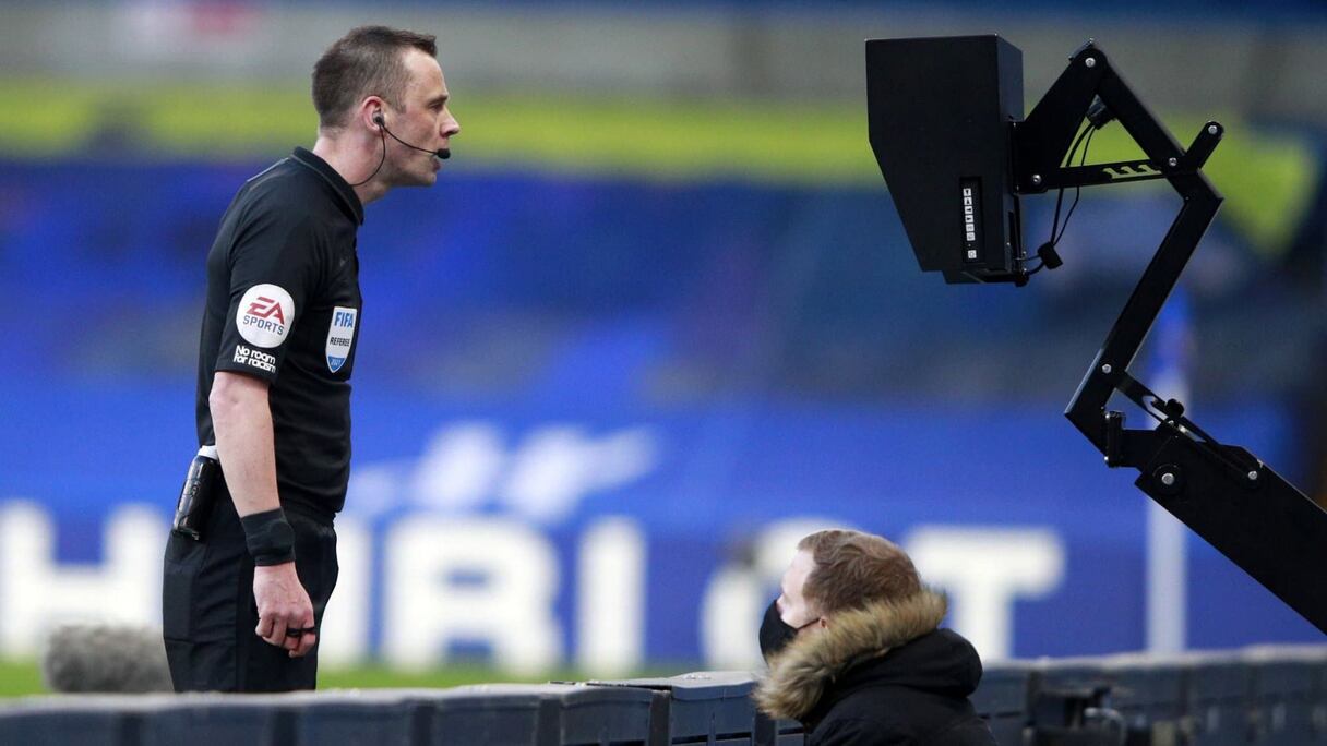 Un arbitre consultant la VAR.