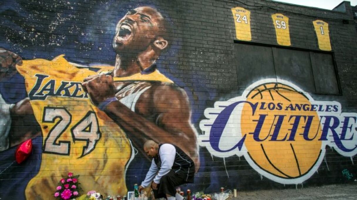Un fan allume une bougie devant une fresque représentant Kobe Bryant le 26 janvier 2020 à Los Angeles.